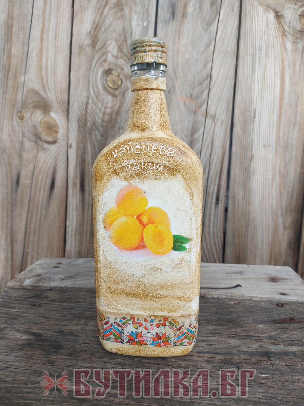 Фолклорно украсена бутилка за кайсиева ракия - идеалният подарък за традиционалистите и ценителите на автентичния вкус.